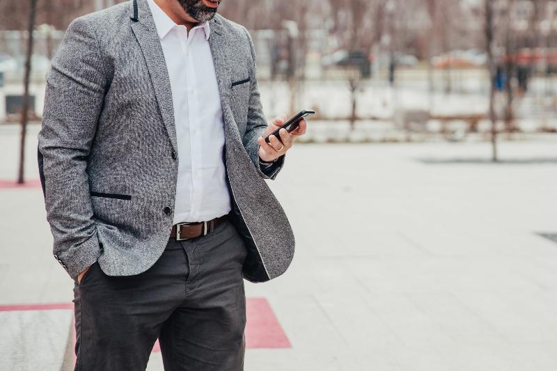 Business man using smartphone in office, checking mobile for work-related tasks and communication