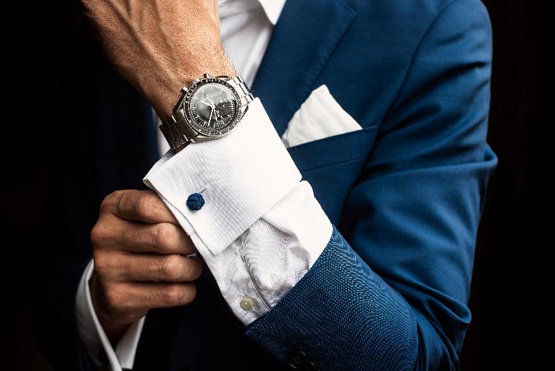 Man adjusts his shirt cuffs below luxury watch, highlighting elegance and sophisticated style